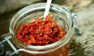 Słoik pełen aromatycznego, czerwonego pesto z suszonych pomidorów, gotowy do użycia.