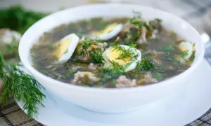 Zupa szczawiowa przepis babci: aromatyczna, zielona z dodatkiem mięsa i jajka, udekorowana świeżym koperkiem.