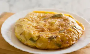 Złocista tortilla ziemniaczana z papryką na talerzu. Idealne śniadanie bez chleba, sycące i pyszne.