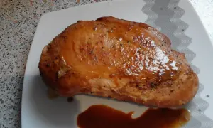 Soczysty filet z indyka w sosie własnym, przygotowany przez Anię. Danie prezentuje się apetycznie na białym talerzu.