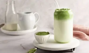Idealny matcha latte przepis: zielony proszek, mleko i gotowy napój w szklance z rurką.
