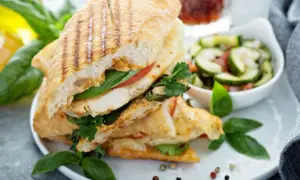 Pyszne panini z kurczakiem, pomidorem i bazylią, podane z sałatką z ogórka. Idealne na szybki lunch.