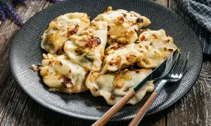 Pyszne pierogi z cebulką na talerzu. Zastanawiasz się, ile gotować pierogi, by były idealne? Te wyglądają na gotowe do jedzenia!
