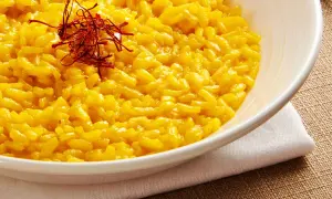 Aksamitne risotto alla milanese, bogato zdobione nitkami szafranu, kusi swoim złocistym kolorem i kremową konsystencją.