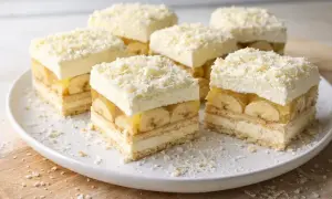 Pyszna krajanka z bananami, galaretką i bitą śmietaną, posypana wiórkami białej czekolady.