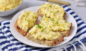 Pyszna pasta jajeczna z twarogiem na chlebie, posypana szczypiorkiem i pieprzem. Idealna na śniadanie lub przekąskę.