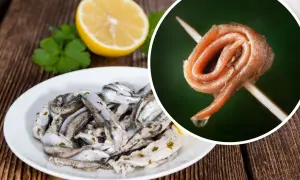 Na talerzu marynowane **anszua** z cytryną i natką. Obok, na wykałaczce, zwinięty filet.