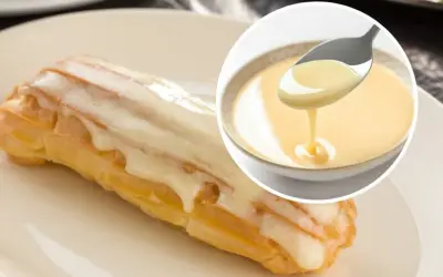 Słodkie eclair oblane lukrem, obok miseczka z kremowym custard. Pyszny deser!