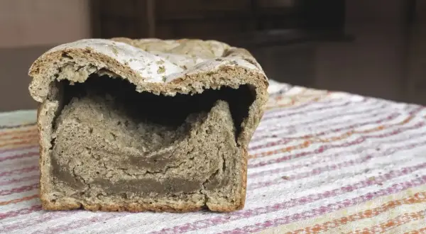 Chleb z zakalcem, z opadniętym środkiem i twardą skórką. Wygląda jakby się zapadł w sobie.