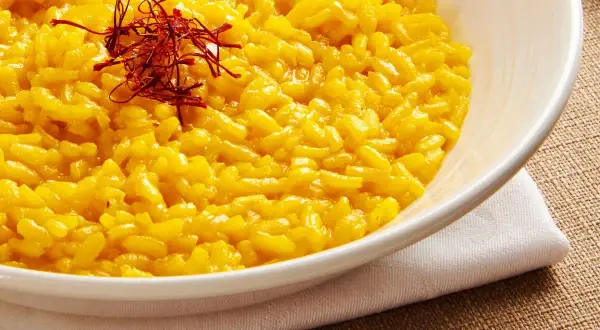 Aksamitne risotto alla milanese, bogato zdobione nitkami szafranu, kusi swoim złocistym kolorem i kremową konsystencją.