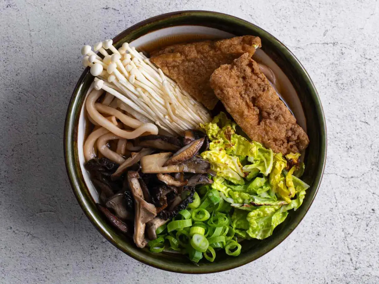 Miseczka z makaronem udon, grzybami enoki, shiitake, smażonym tofu, kapustą i szczypiorkiem. Idealny makaron udon przepis na szybki obiad.