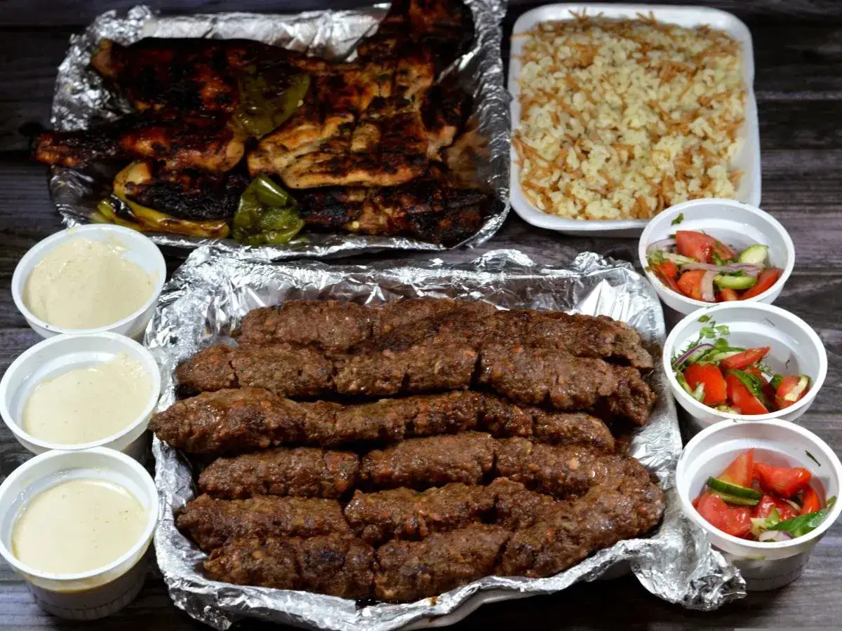 Pyszny kofta kebab z ryżem, sałatką i sosami. Idealny posiłek dla miłośników mięsa.