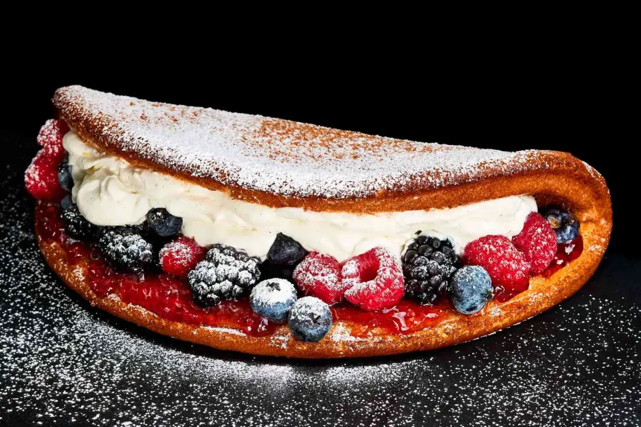 Słodki omlet z bitą śmietaną, dżemem i świeżymi owocami leśnymi. Idealny przepis na omlet na słodko.