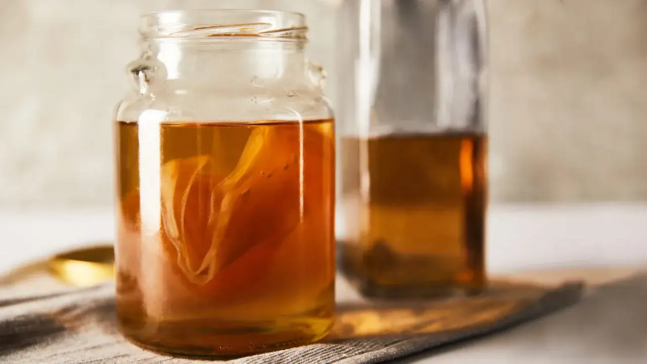 Słoik z kombuchą, napojem fermentowanym. Zastanawiasz się, kombucha co to? To zdrowy napój z herbaty i grzybka herbacianego.