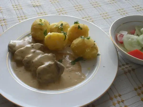 Pyszne mięso w sosie śmietanowym z ziemniakami i surówką. Idealny obiad.