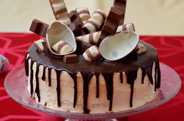 Tort oblany czekoladą, udekorowany batonikami Kinder Bueno i połówkami jajek. Idealny krem kinder bueno do tortu.
