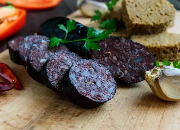 Kaszanka pokrojona w plastry, z pieczywem, czosnkiem i papryką. Czy kaszankę można mrozić? Tak, można ją mrozić.