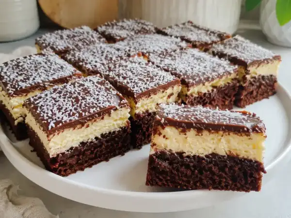 Izaura ciasto które zawsze wychodzi: ciemny biszkopt, jasny krem i czekoladowa polewa z wiórkami kokosowymi.