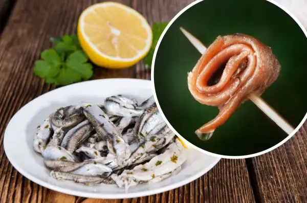 Na talerzu marynowane **anszua** z cytryną i natką. Obok, na wykałaczce, zwinięty filet.